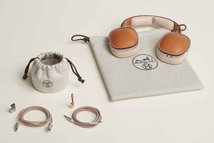A pair of Hèrmes headphones showing their carrying bag and cables