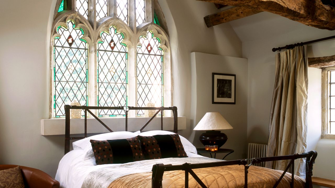 Bedroom iron bed arched gothic stained glass windows 