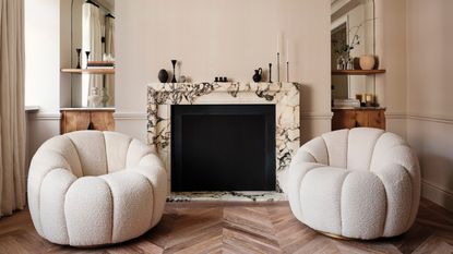 Two white accent chairs in the modern living room of a renovated west London flat