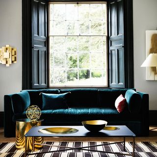 living room with teal sofa and brass accessories