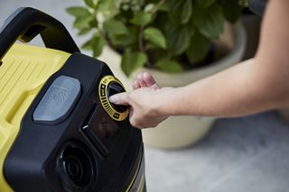 A woman turns a button on a vaccuum
