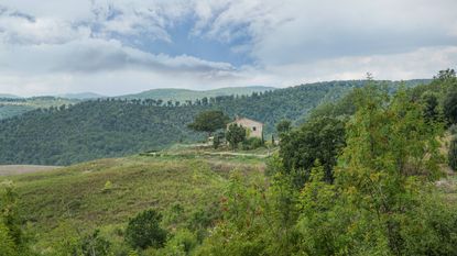 stone villa in Tuscany surrounded by rolling hills and trees