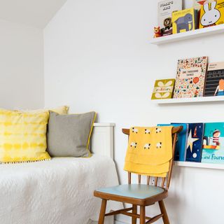 exterior of scandi house childrens room with picture ledges bedspread and chair