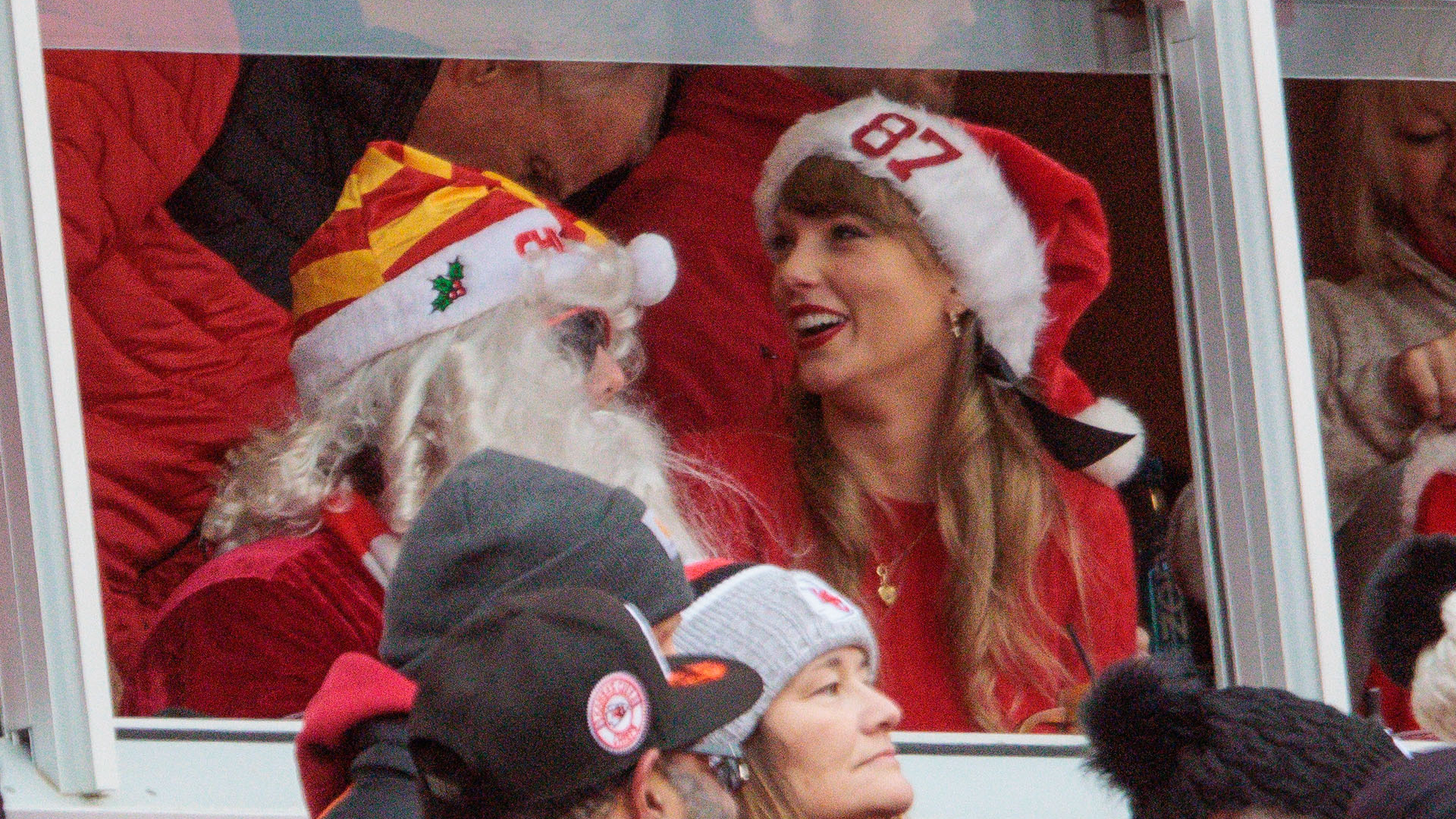 Taylor Swift at the Kansas City Chiefs Christmas day game in 2023 wearing a red sweater and plaid skirt with a santa hat