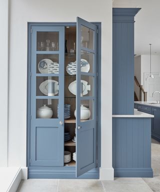 Kitchen cupboard storage ideas featuring blue wood and glass fronted cabinets.