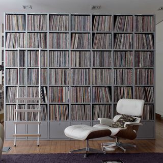 arm chair with foot stool and books on shelving