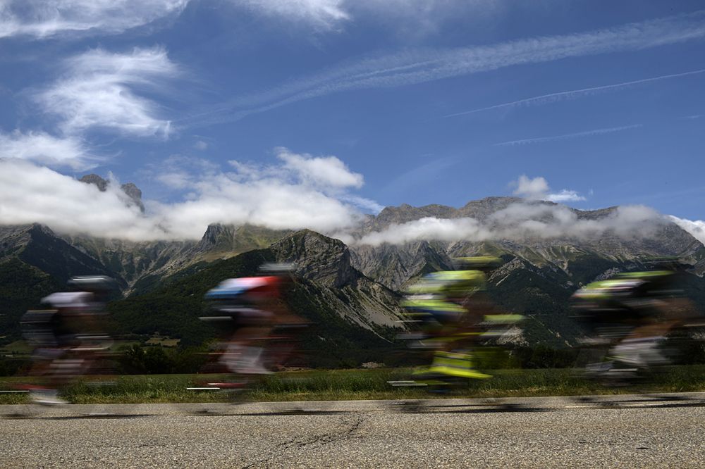The field speeding by the mountainous backdrop at the Tour de France
