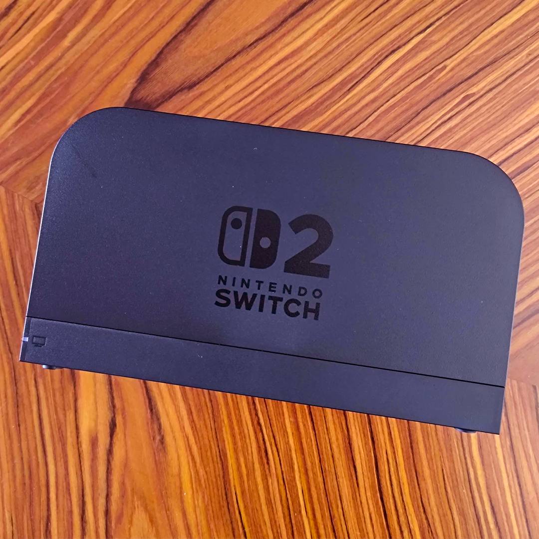 Nintendo Switch 2 dock on woodgrain table.