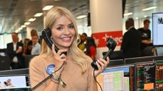 a headshot of holly willoughby holding two phones