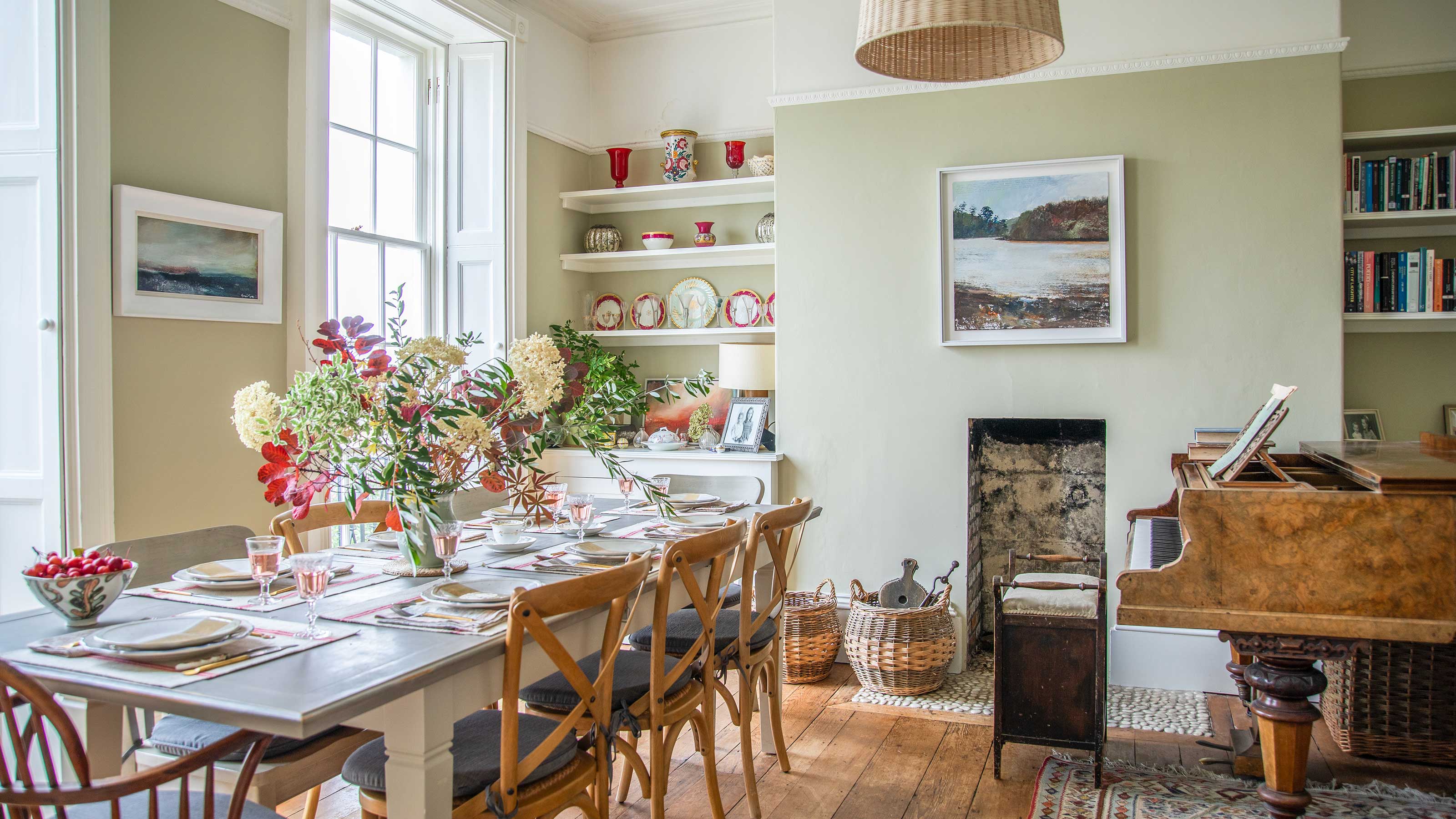 dining room in a georgian villa with antique furniture, grand piano an pale green painted walls