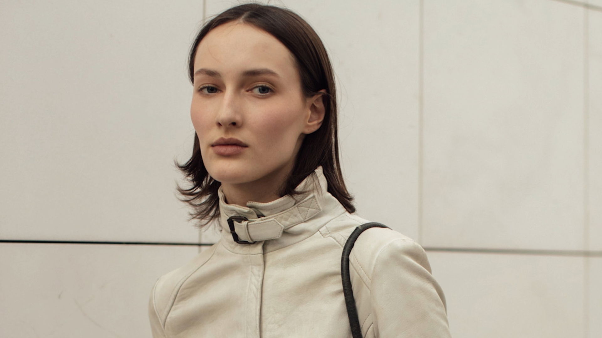 woman wearing a tan high-collar coat.