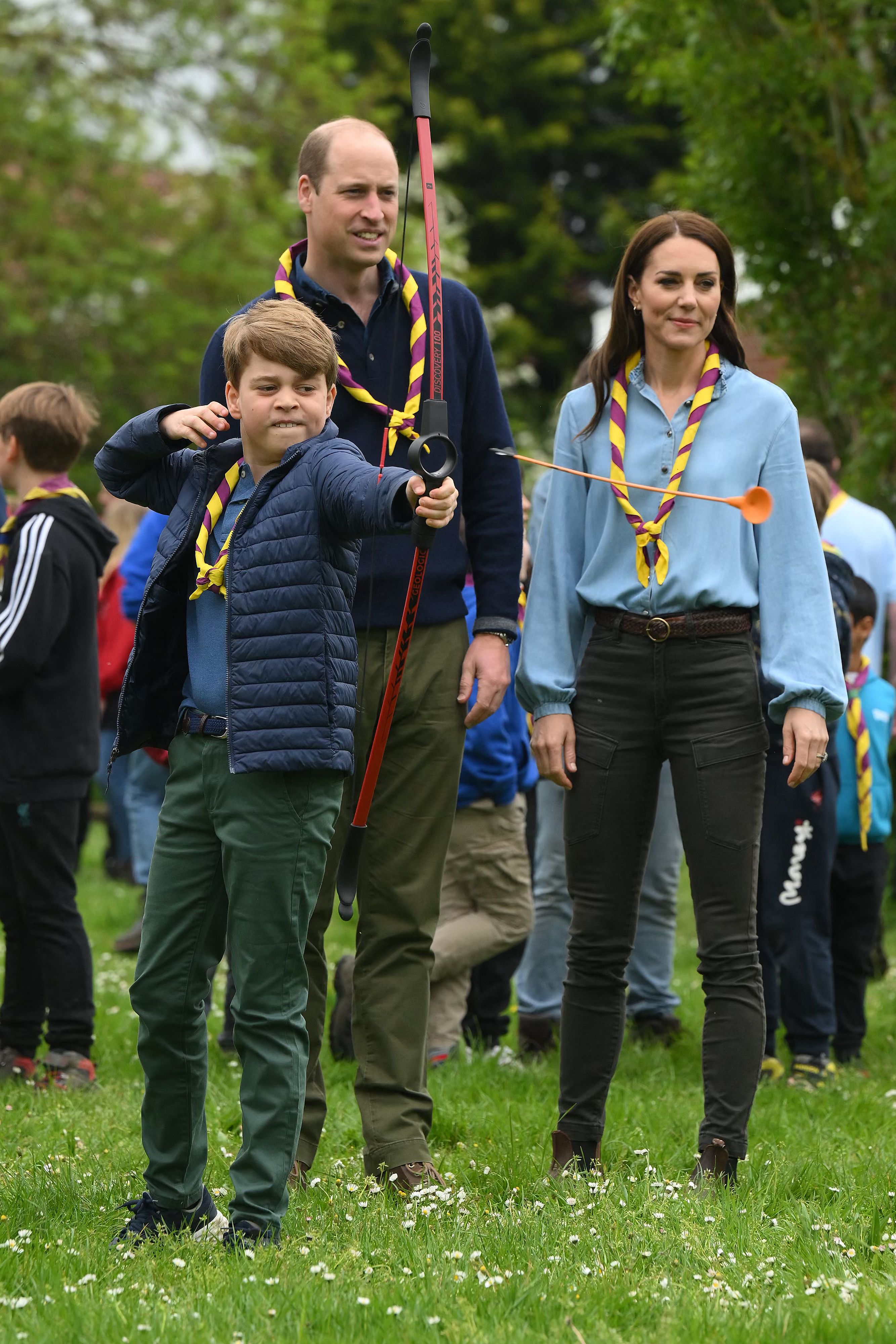 Prince George shooting an archery arrow as Kate and William look on