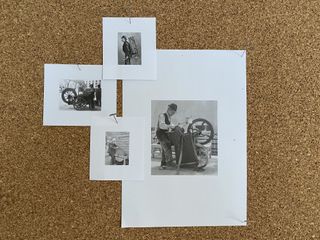 Black and white photographs pinned to a brown board