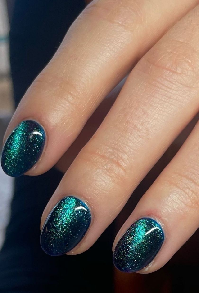 a close-up shot of deep teal velvet nails