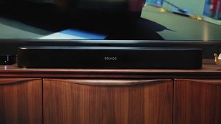 The Sonos Beam soundbar pictured on a wooden cabinet