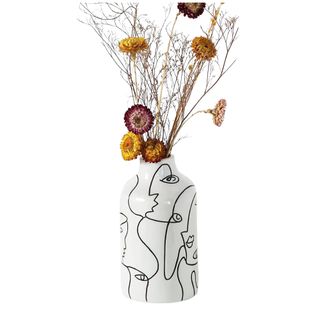 A black and white vase with flowers in it, on a white background.