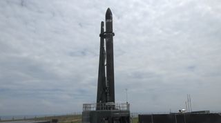 The Rocket Lab Electron booster carrying 13 small satellites, including 10 cubesats for NASA's ElaNa-19 mission, stands atop its launchpad on the Mahia Peninsula of New Zealand's North Island ahead of a Dec. 13, 2018 launch attempt. Bad weather delayed the launch.