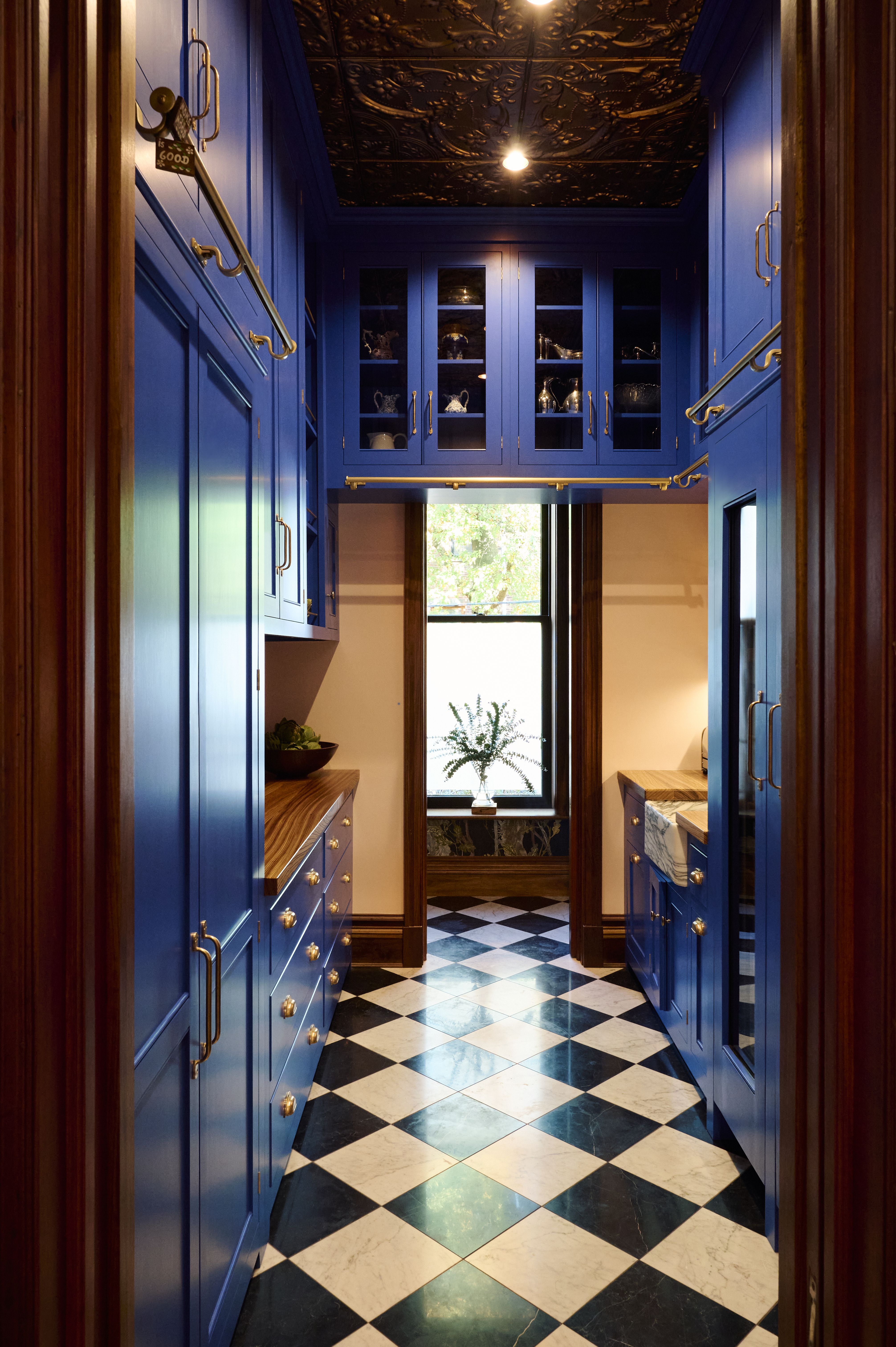 Two kitchens with black&amp; white chequerboard flooring, and saturated blue cabinets 