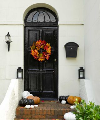 black gloss door painted with Sandtex with halloween wreath and pumpkins