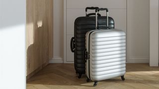 Two hardshell suitcases sitting on wooden floor