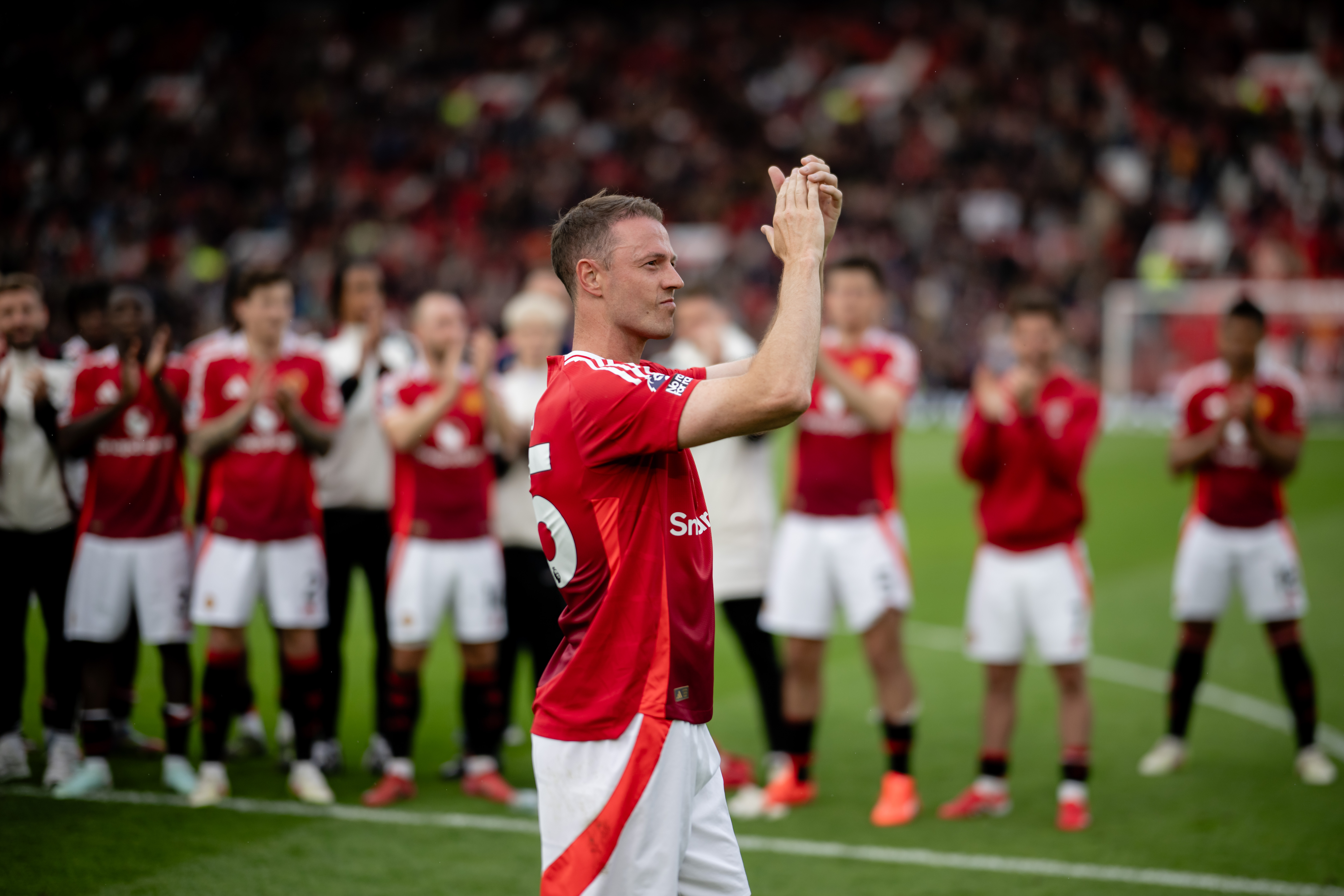 Jonny Evans applauds Manchester United fans after a Premier League game against Aston Villa in May 2025, his final appearance for the club.