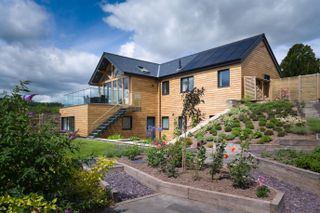 timber clad self build with large sloping garden