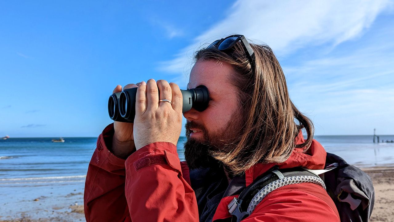 Tester using the Canon 10x32 IS binoculars at the beach