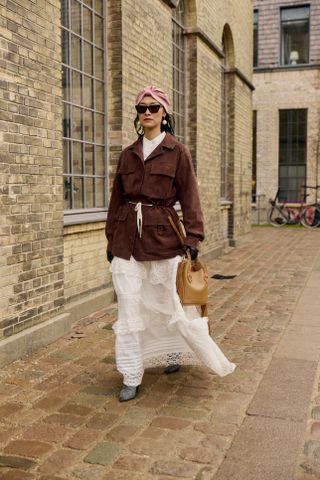 Influencer wears a leather jacket and white skirt.