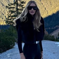 rosie wears a black ski outfit with large sunglasses.