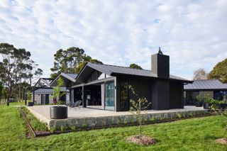 Black pitched-roof volumes that comprise this renovated Australian farmhouse