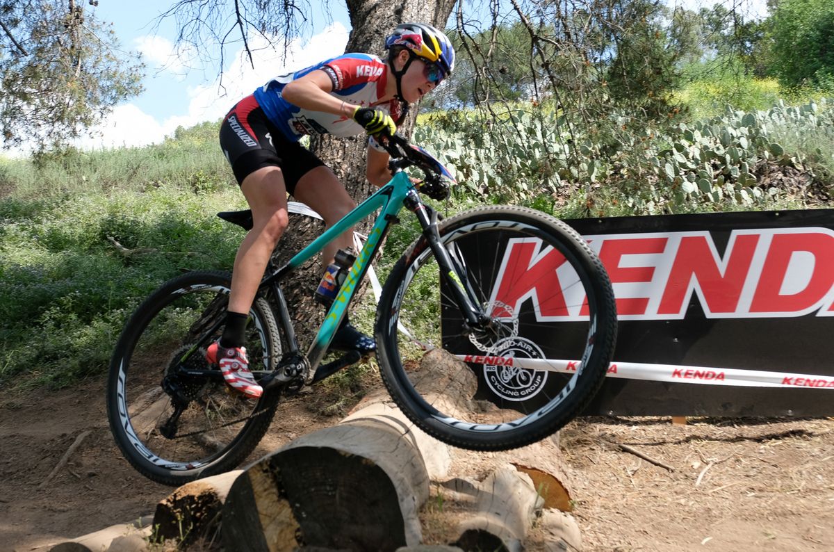 Kate Courtney (Specialized) crossing a man-made log barrier
