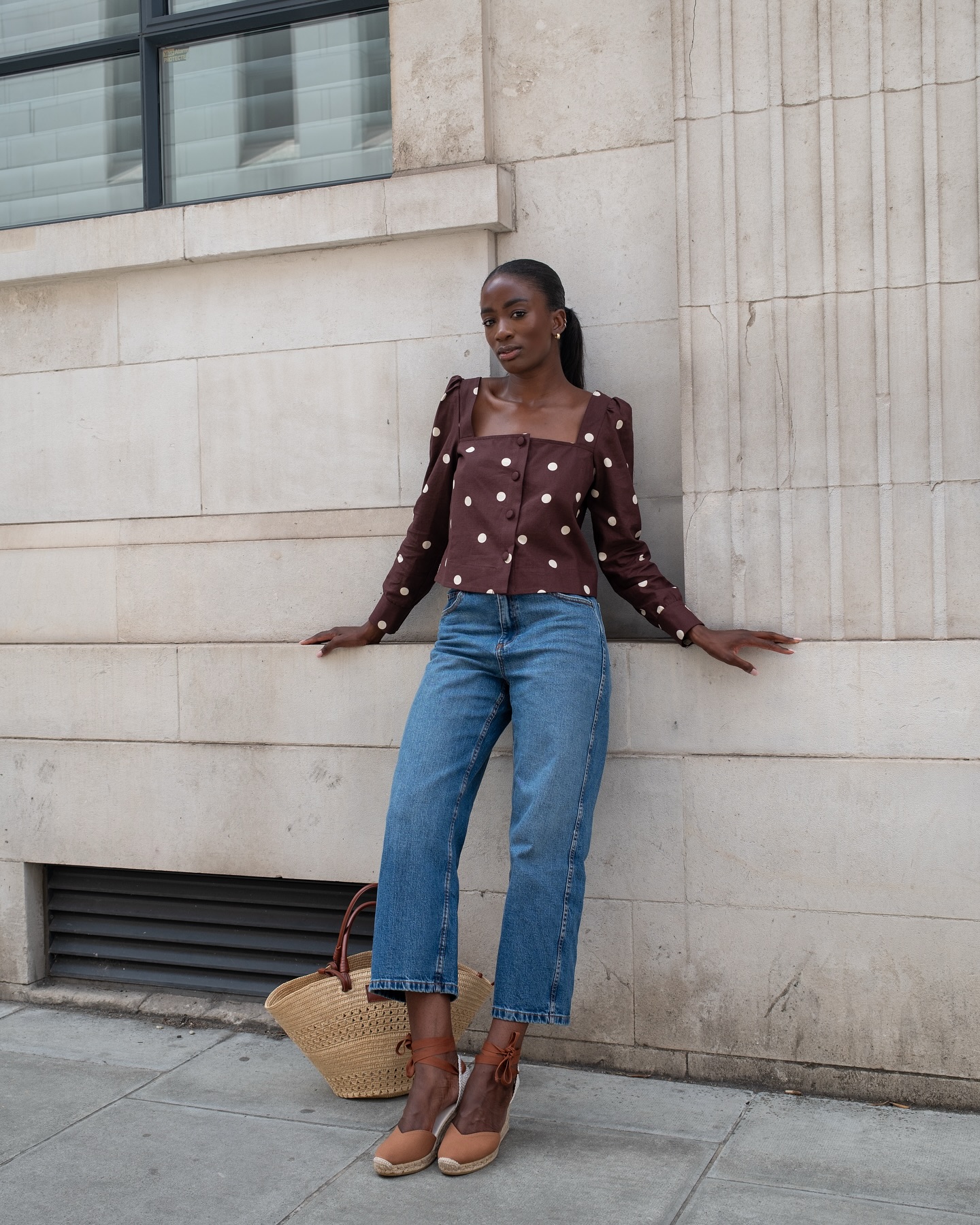 @_livmadeline wears a brown polkadot top, blue jeans and espadrille mules