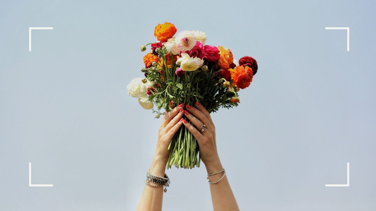 Woman&#039;s hands holding up a bouquet of flowers, representing gifts received in a rebound relationship