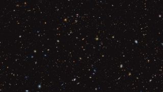 a wide view of deep space containing hundreds of galaxies