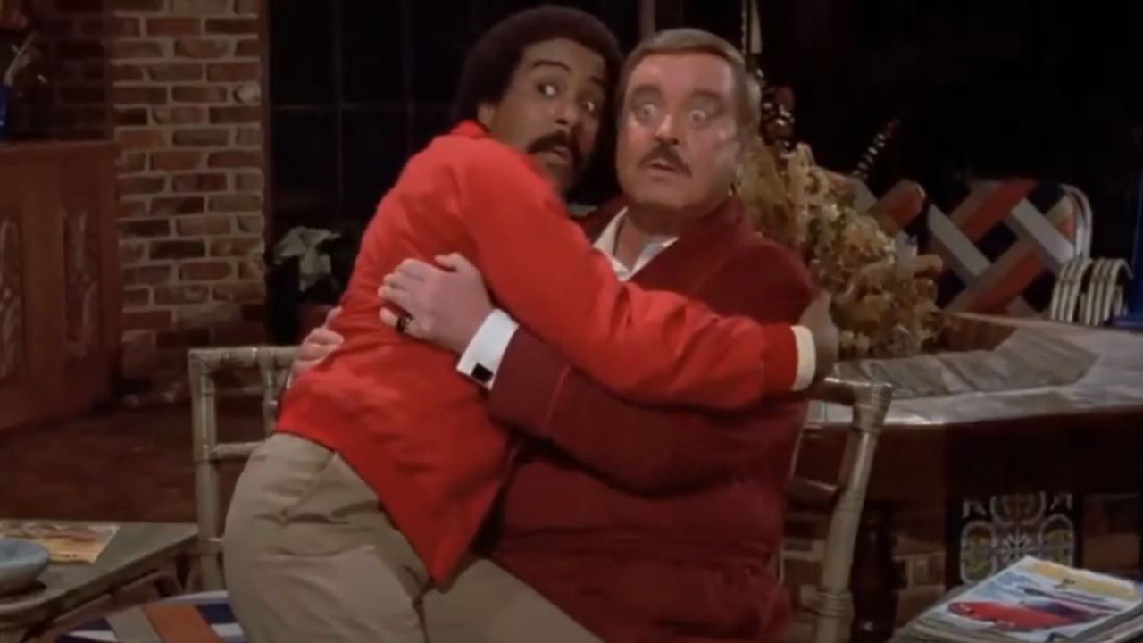 Richard Pryor sitting on Jackie Gleeson's lap with a look of fright in The Toy.