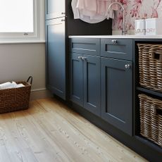 White walls with wooden flooring and black cabinet