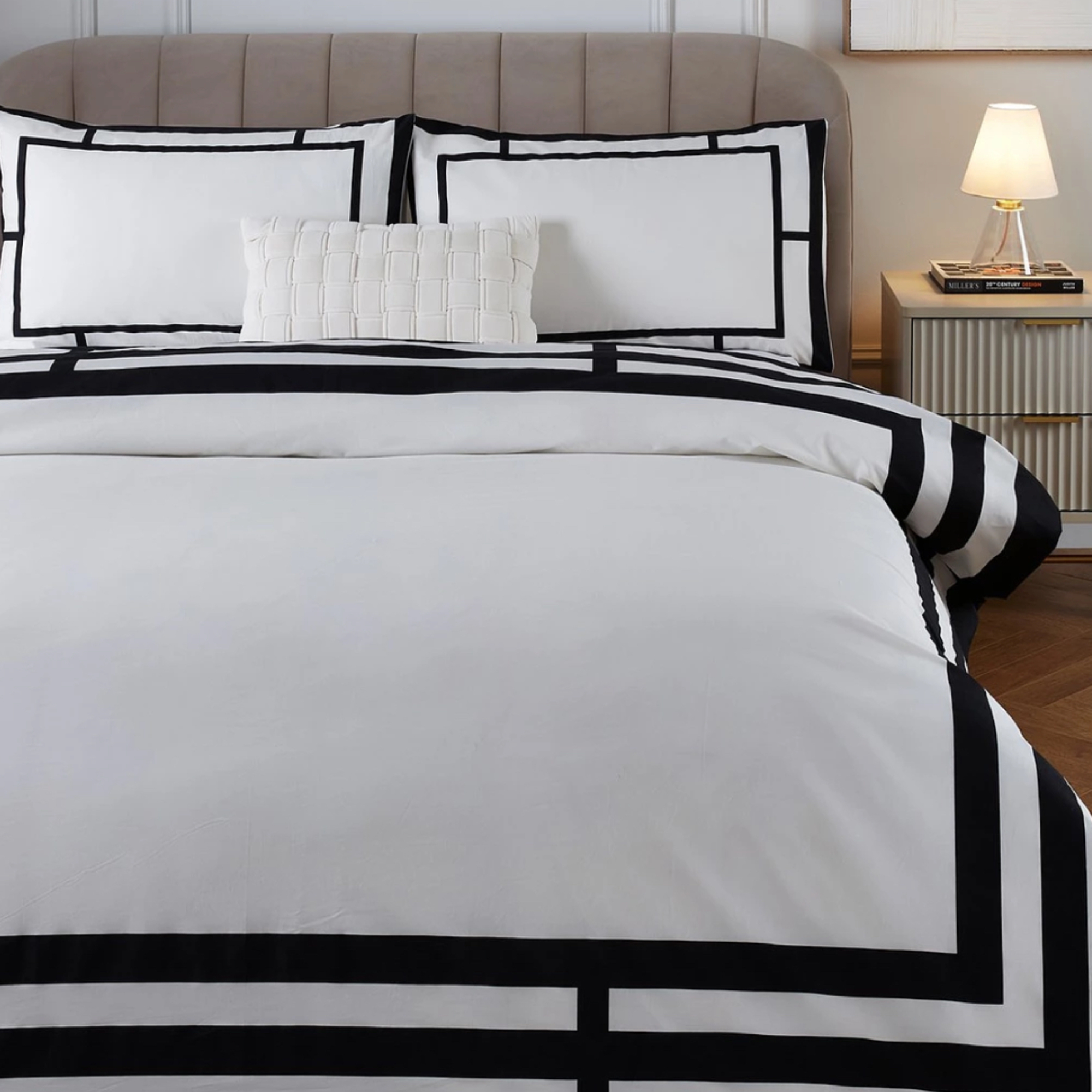 White bedding with black border on a double bed in a neutral bedroom