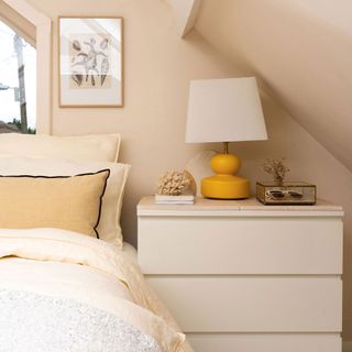 Guest bedroom with white dresser and yellow lamp