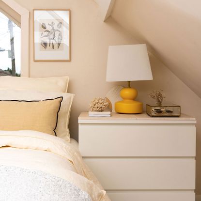 Guest bedroom with white dresser and yellow lamp 