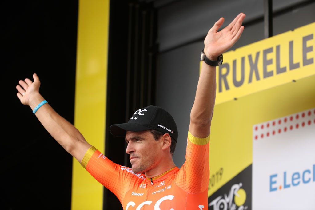 CCC Team&#039;s Greg Van Avermaet – on the podium to collect the polka-dot jersey after stage 1 of the 2019 Tour de France in Brussels – salutes the crowd, wearing his blue &#039;CCC Team for UNICEF&#039; wristband and with the UNICEF logo on his team jersey