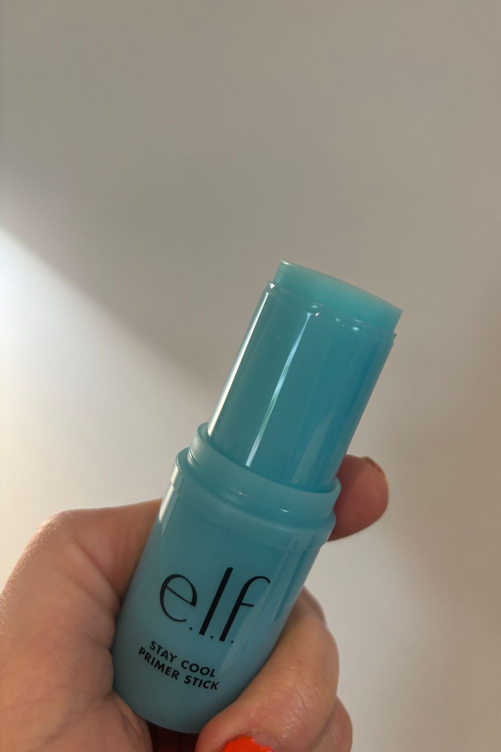 a hand holding e.l.f stay cool primer