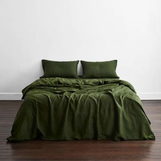 Dark colored bedding styled on bed 