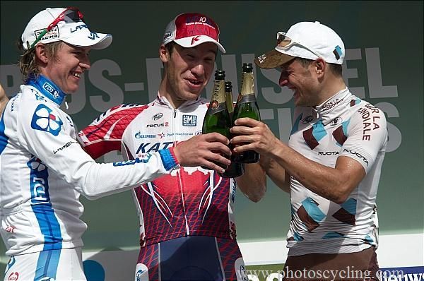 The top three celebrate on the podium with a toast