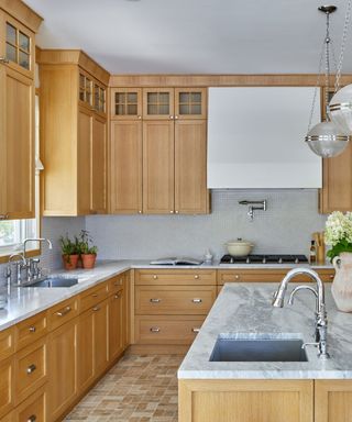 A kitchen with wooden cabinetry and a bright white range hood