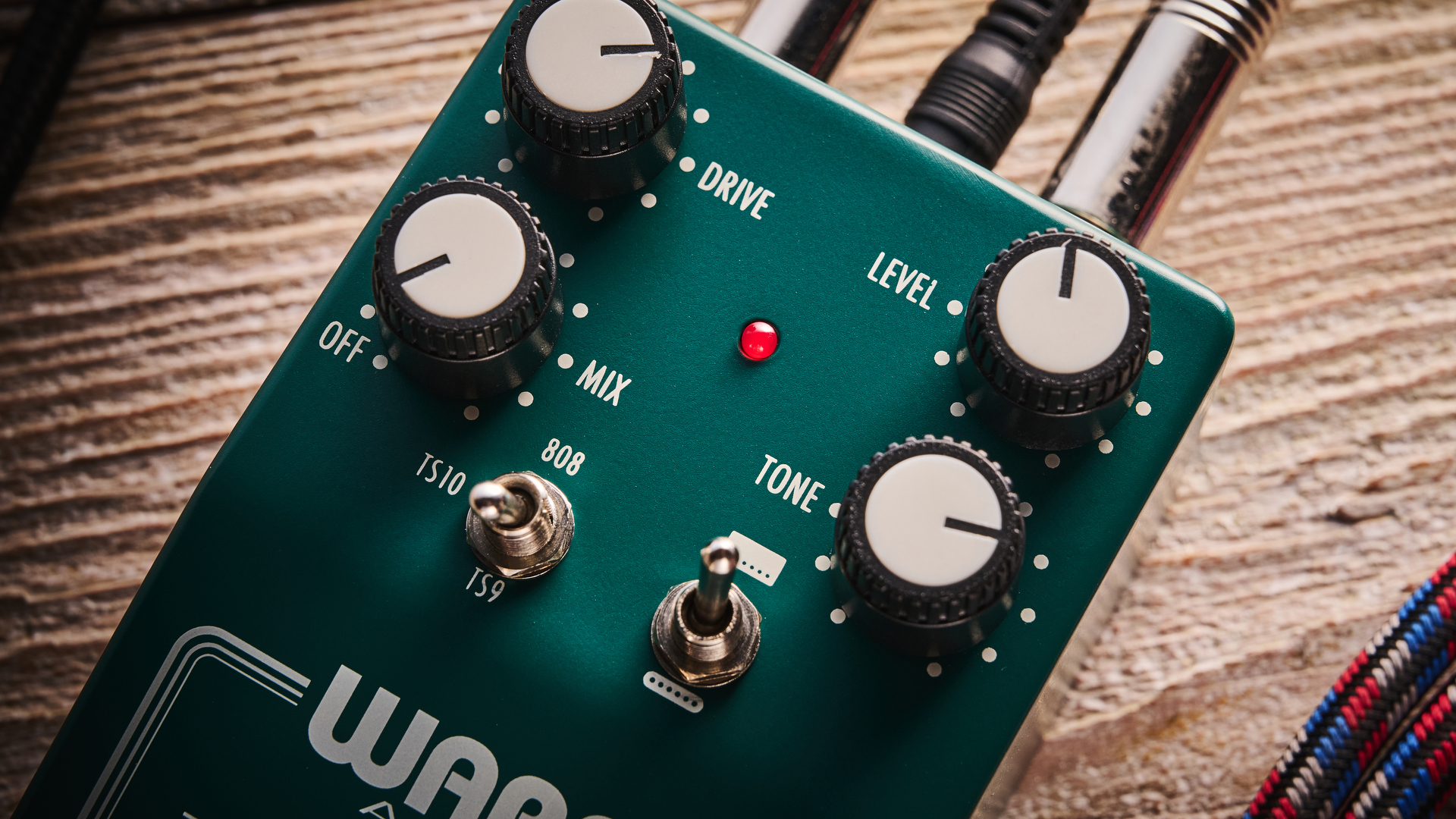 Warm Audio Tube Squealer green overdrive pedal shot on wood floorboards