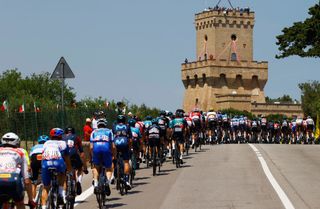 The pack of riders cycles near the Torre del Cerrano tower during the 10th stage of the Giro dItalia 2022 cycling race 196 kilometers between Pescara and Jesi central Italy on May 17 2022 Photo by Luca Bettini AFP Photo by LUCA BETTINIAFP via Getty Images