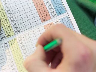 golfer marking scorecard