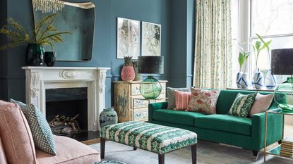 blue living room with green and pink couches and large mirror