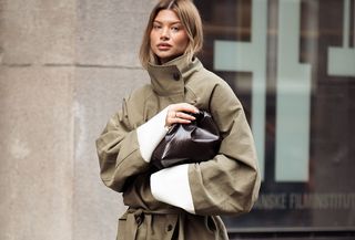 Woman in trench coat and brown bag.