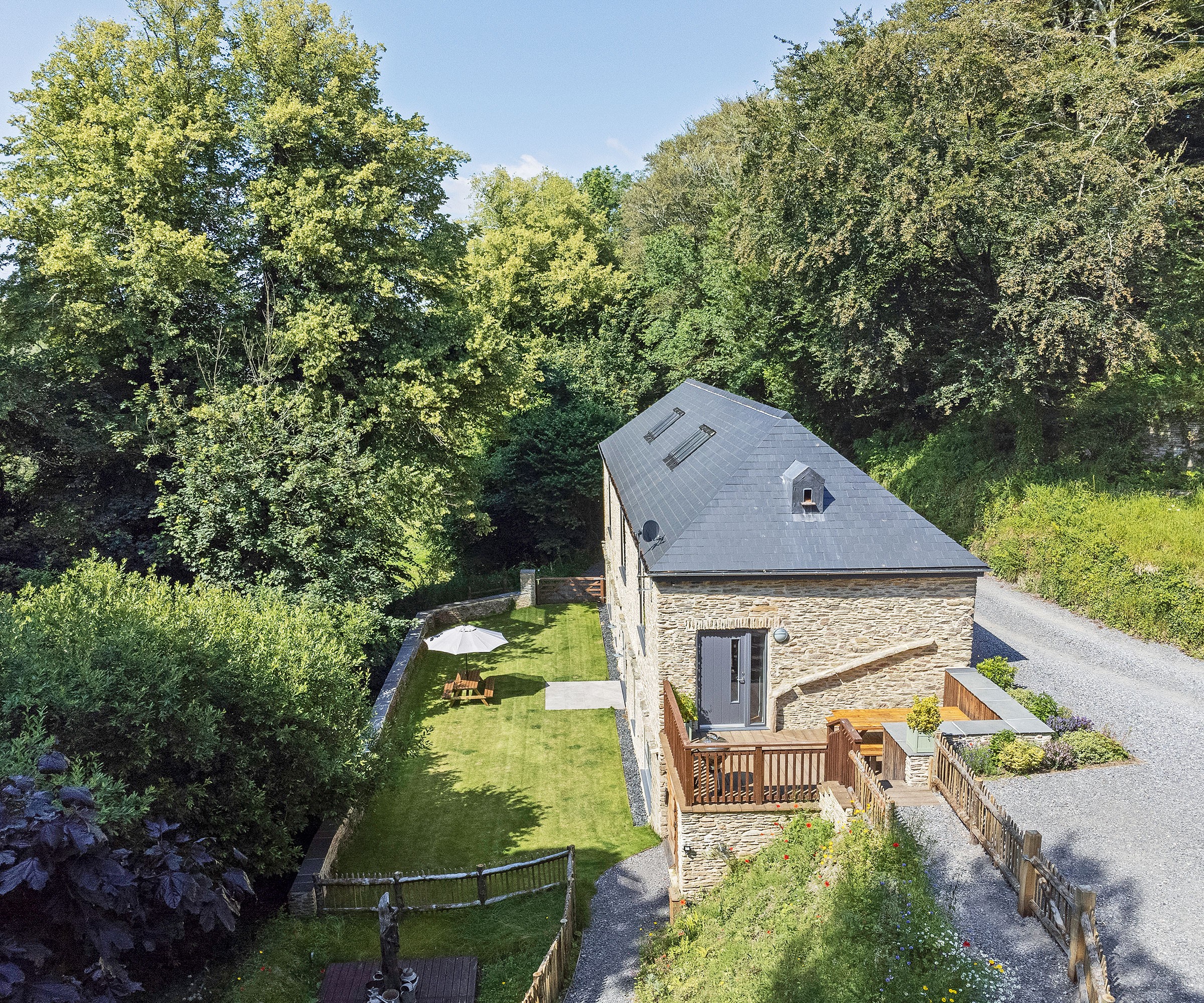 aerial view of a barn conversion project with slate roof and a lawned garden to the rear of the house